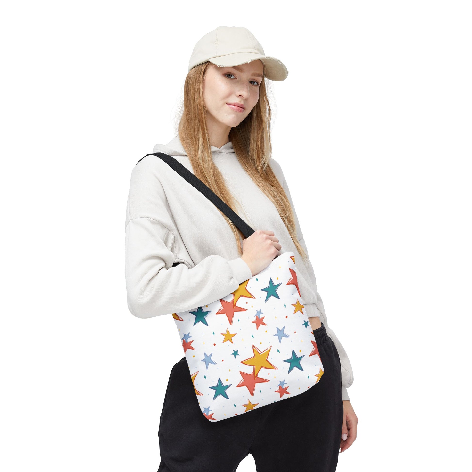 Person holding a white bag with colorful star patterns on a white background